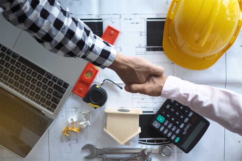 Shaking hands Construction-Law-middle-image-OPT-Med-30 Two men shaking hands above construction related items
