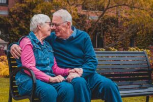 Elderly couple sitting on a park bench representing wills, trusts & estates